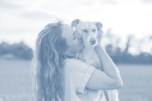 Frau mit ihrem Hund auf dem Arm
